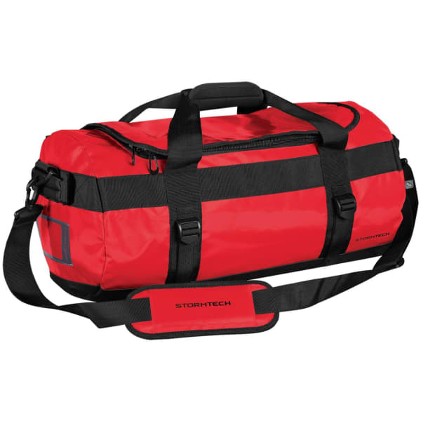 A red duffle bag with black straps and a handle, featuring a logo and adjustable shoulder strap.