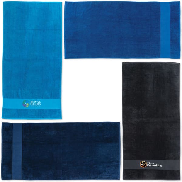 A set of four beach towels in shades of blue and black, featuring logos and branding on some.