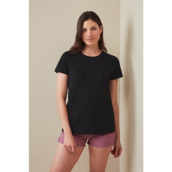 A black women's heavyweight comfort T-shirt displayed on a model, paired with pink shorts. The shirt has a simple design and a logo.