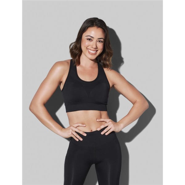 A black women's sports bra featured on a model, accompanied by matching black leggings. Branding is present.