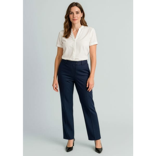 A woman stands wearing a white shirt and navy blue relaxed pants. The pants have a logo on them.