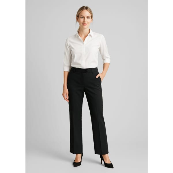 Black wool stretch adjustable waist pants paired with a white button-up shirt and high heels. The model stands with one hand in a pocket.