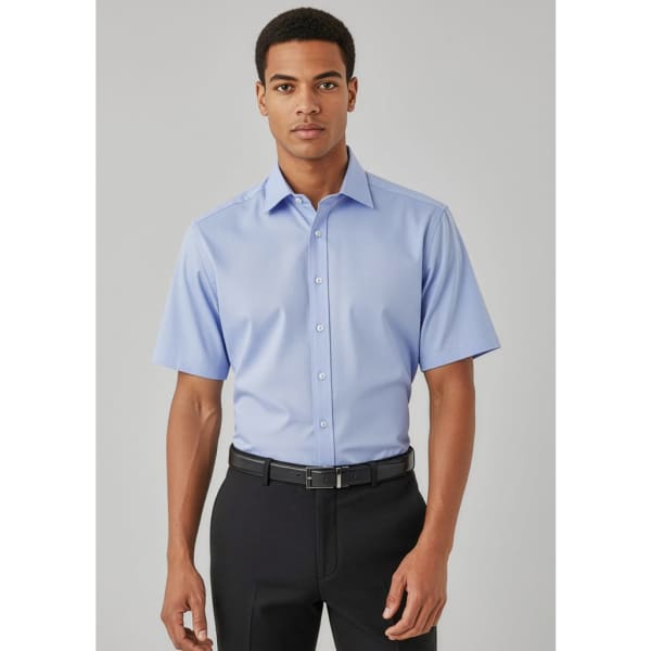 A short-sleeve button-up shirt in light blue, featuring a collar and a logo. Styled with black trousers and a belt.