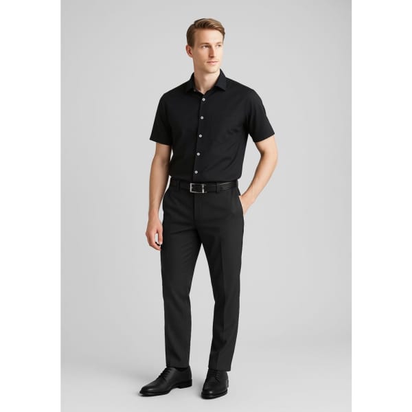 A pair of black slimline pants made of wool stretch, modelled by a man in a black short-sleeve shirt and belt.