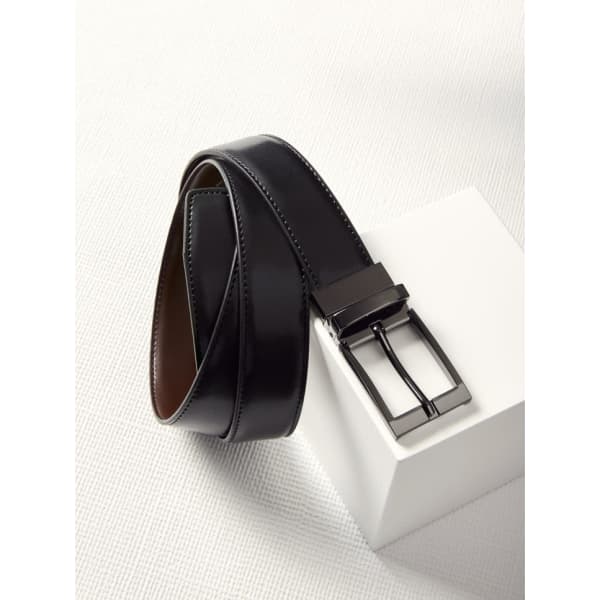 A black leather reversible belt with a rectangular metal buckle, featuring a smooth finish and contrasting interior.