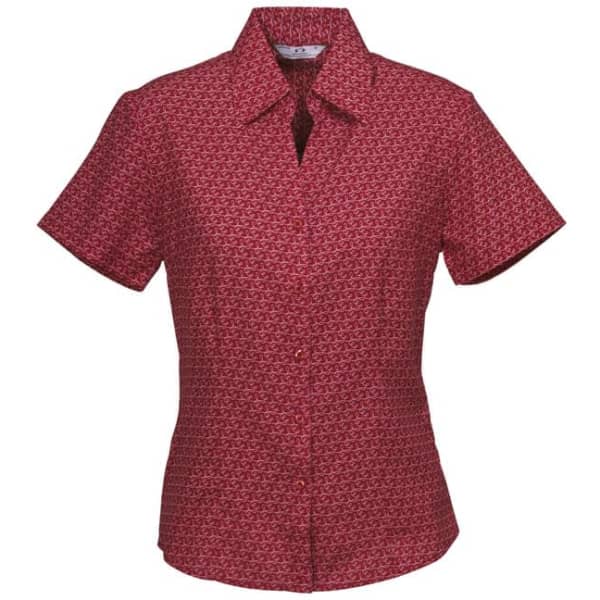A short sleeve button-up shirt in a red and patterned fabric, featuring a collar and a logo.
