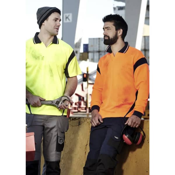 Two men wearing high visibility polo shirts in yellow and orange, with workwear trousers and safety gear.