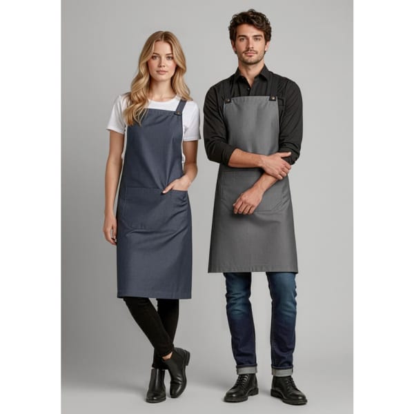 Two models wearing Urban Bib Aprons in navy blue and grey, featuring pockets and adjustable straps. Each apron has a logo.
