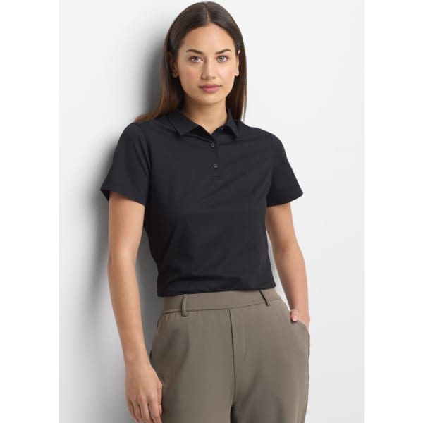 A black women's short sleeve polo shirt displayed on a model, featuring a subtle logo.