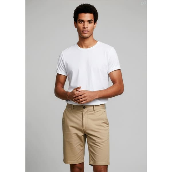 A male model wearing khaki dress shorts paired with a white t-shirt, standing against a neutral background.