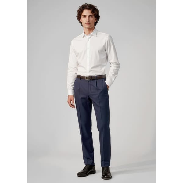 A man models classic pleat pants in navy, paired with a white shirt and black shoes. The image includes branding.