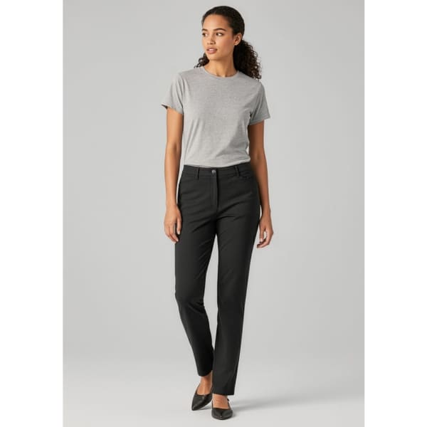A woman wearing black venture pants and a grey t-shirt, standing confidently in a neutral setting. The pants have a logo.