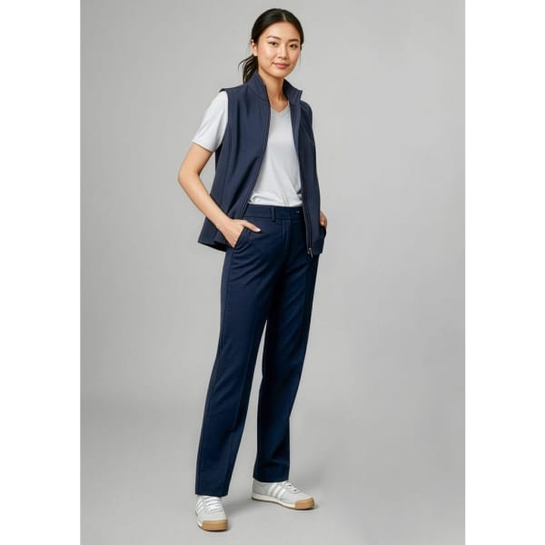 A pair of navy women's slacks, styled with a white t-shirt and navy vest, featuring a logo on the vest.