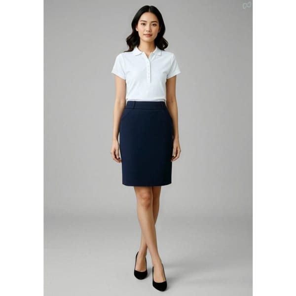 A fitted women's skirt in navy blue, paired with a white polo shirt and black heels. The model stands against a neutral background.
