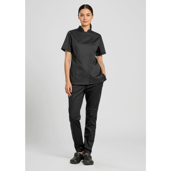 A woman wearing black Cajun chef jogger pants and a matching short-sleeve chef top, with a logo on the top.