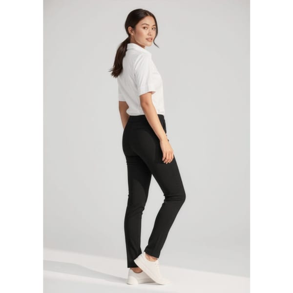 A woman wearing black stretch pants and a white shirt, posed sideways against a neutral background.