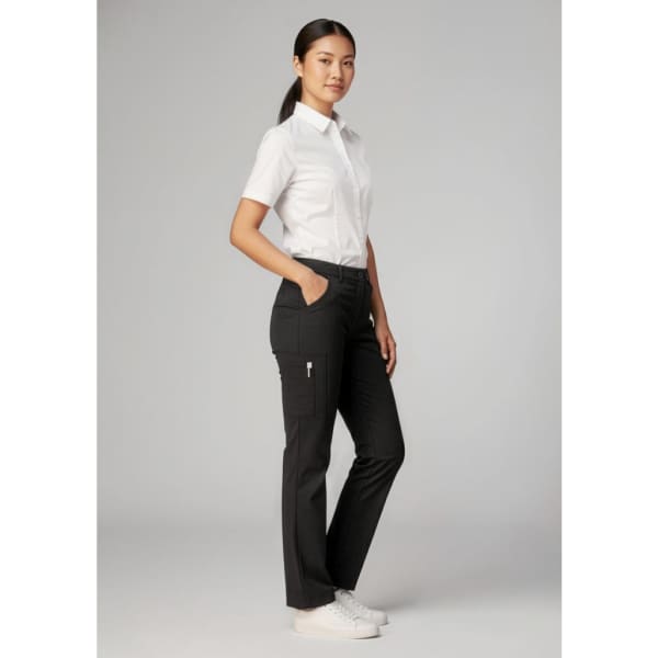 A woman wearing black women's comfort waist cargo pants and a white shirt, standing with one hand in her pocket.
