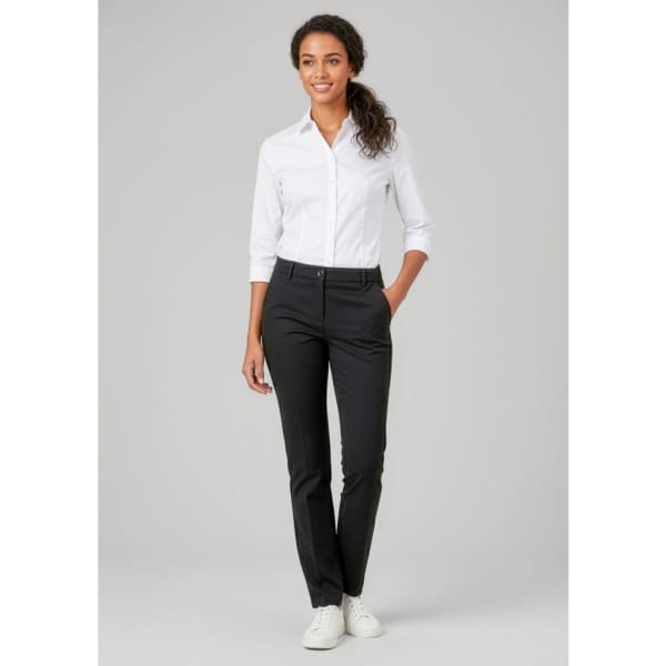 A woman wearing black straight leg pants and a white shirt, featuring a logo on the pants.