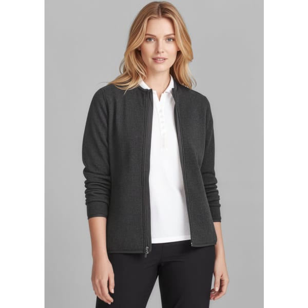 A woman wears a dark grey polar fleece jumper with a zip front, paired with a white top and black trousers.