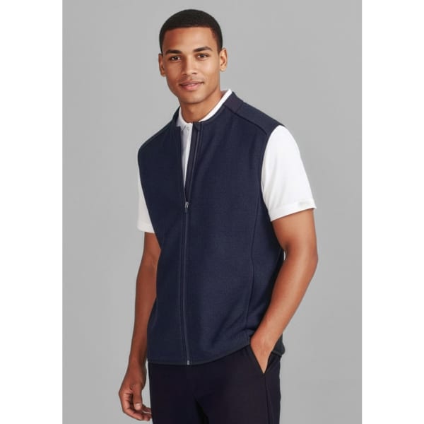A navy zip-front vest worn over a white polo shirt, featuring a gentle collar and a logo on the left side.
