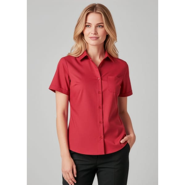 A red short sleeve button-up shirt for women, featuring a pocket and a logo.