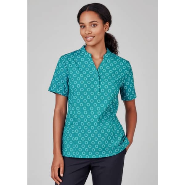 A teal women's tunic with a daisy print pattern, featuring short sleeves and a simple collar design.