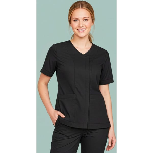 A woman in a black scrub top with a zip front and crossover design, featuring two pockets.