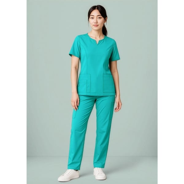A women's scrub top in teal, featuring a round neck and two front pockets, styled with matching pants.