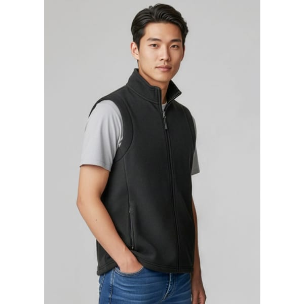 A men's plain micro fleece vest in black, featuring a zip front and side pockets, worn over a grey t-shirt.