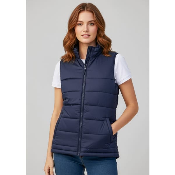 A navy woman's vest with a zip, featuring a quilted design and pockets, worn over a white t-shirt.