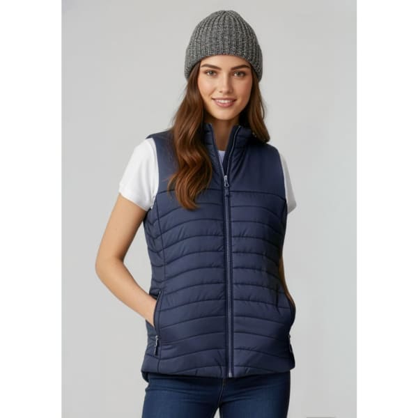 A navy women's vest with a zip front and side pockets, worn over a white shirt, paired with a grey beanie.