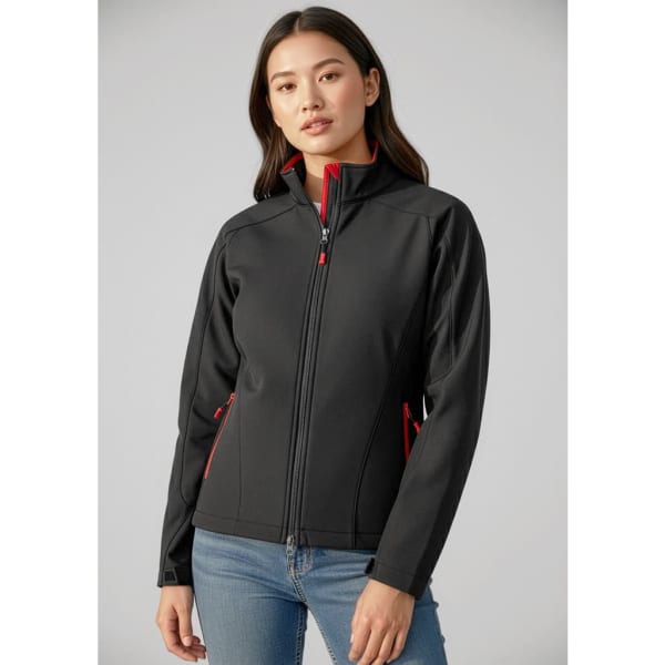 A black soft shell jacket with red accents, featuring a high collar and zippered pockets, modelled by a woman.