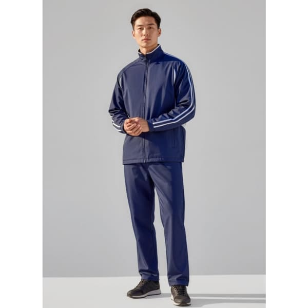 A model wearing unisex navy track pants paired with a matching zip-up jacket featuring white stripes.