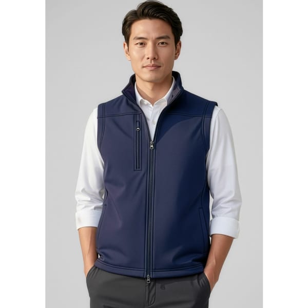 A navy blue men's softshell vest features a zip front and a collar, worn over a white shirt. It has a logo on the chest.