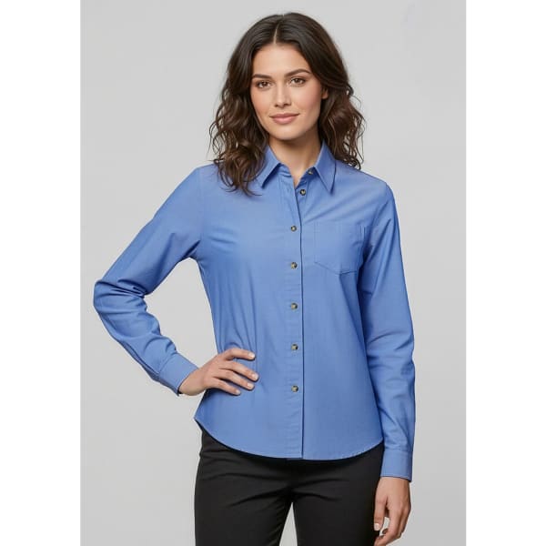A women's long sleeve button-up shirt in light blue, featuring a collar and a chest pocket, with a small logo.