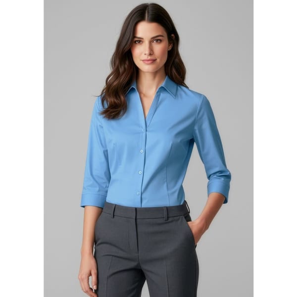 A women's button-up shirt in light blue with 3/4 sleeves, featuring a fitted design and a logo.