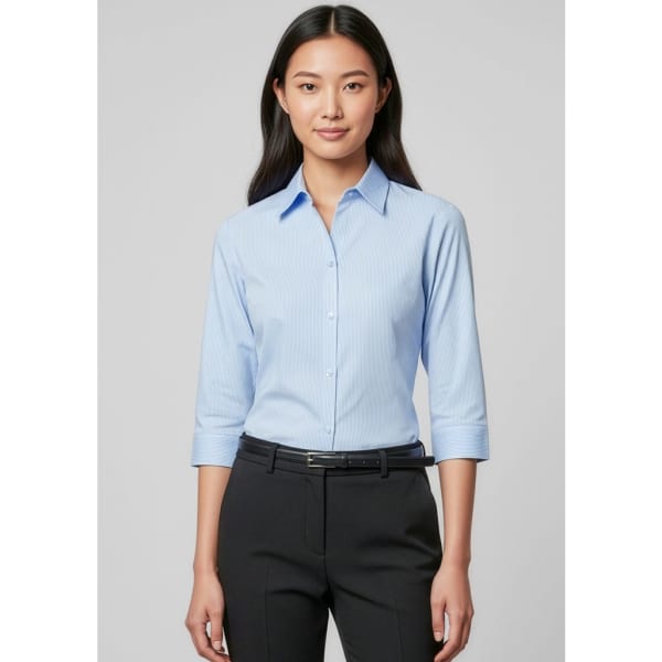 A light blue women's 3/4 sleeve button-up shirt featuring a collar, worn with black trousers. The shirt has a logo.