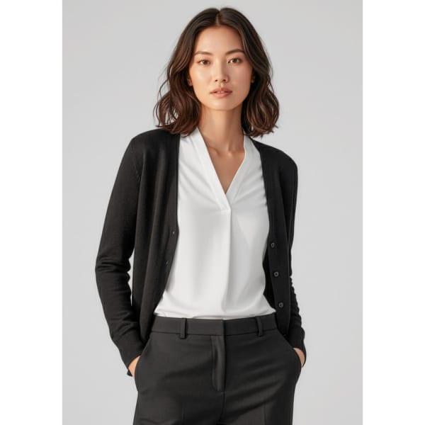 A black women's cardigan with buttons, paired with a white blouse and black trousers, on a model.