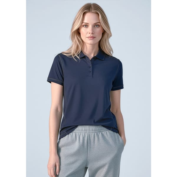 A women's short sleeve polo in navy blue with a classic collar and a logo, paired with grey pants.