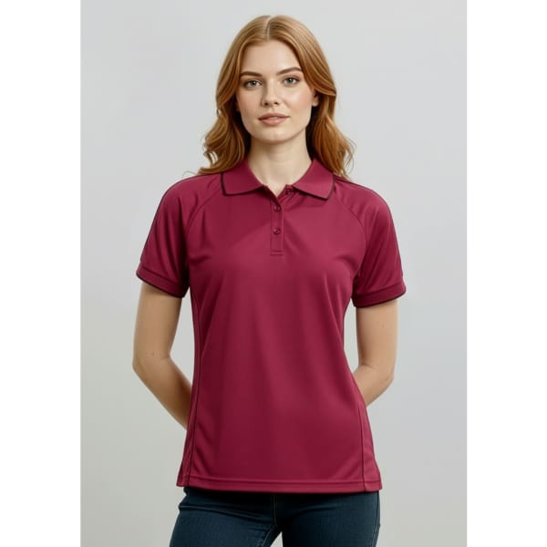 A maroon women's short sleeve polo shirt, featuring a collar and a logo on the chest.