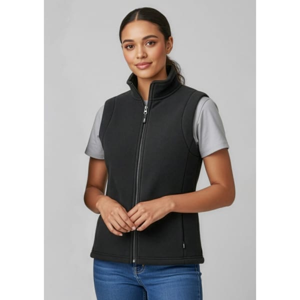 A black micro fleece vest with a zip front and high collar, worn over a grey t-shirt.