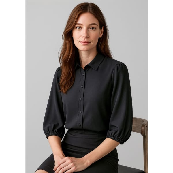 A black women's 3/4 sleeve blouse with a collared neckline and puffed sleeves, displayed on a seated model.