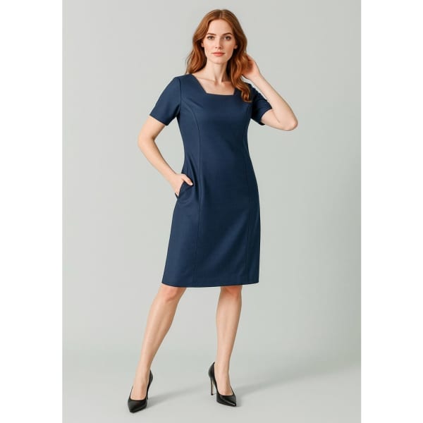 A short sleeve dress in navy blue featuring a square neckline and side pockets, paired with high heels.