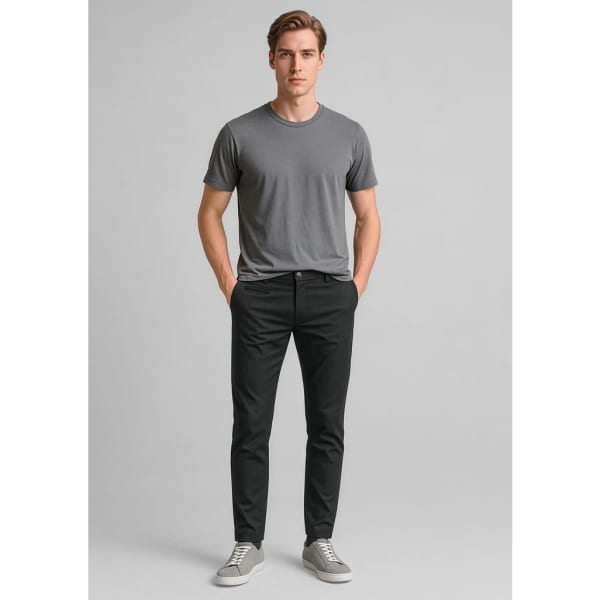 Men's tapered stretch chino pants in black, paired with a grey t-shirt and casual grey shoes. Features branding detail.