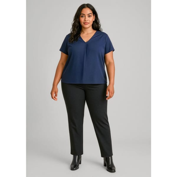 A woman wearing a navy top and black mid-rise pull-on pants, standing against a neutral background.