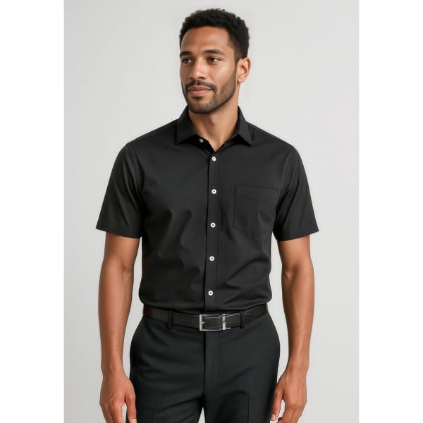 A short sleeve black button-up shirt with a single chest pocket, worn by a man, styled with dress trousers.