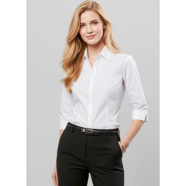 A woman wears a white women's button-up shirt with 3/4 sleeves, paired with black trousers. The shirt features a pocket and has a logo.