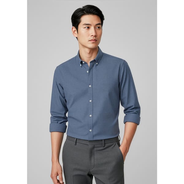 A button-up long sleeve shirt in blue, featuring a collar and rolled-up sleeves, paired with grey trousers.