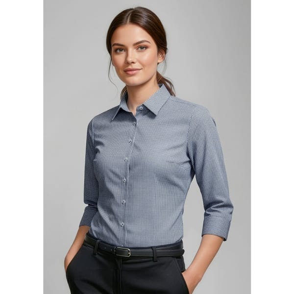 A women's button-up shirt with 3/4 sleeves in a blue and white checkered pattern, featuring a collar and a logo.