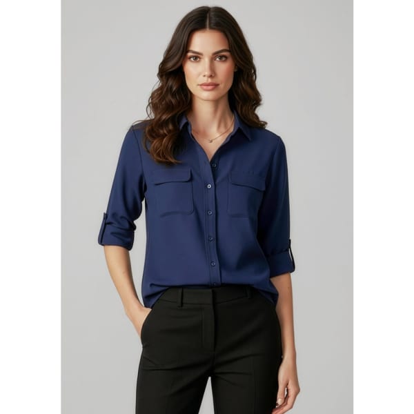 A navy blue women's long sleeve button-up shirt with a collar and two chest pockets. It features rolled sleeves and has a branding logo.